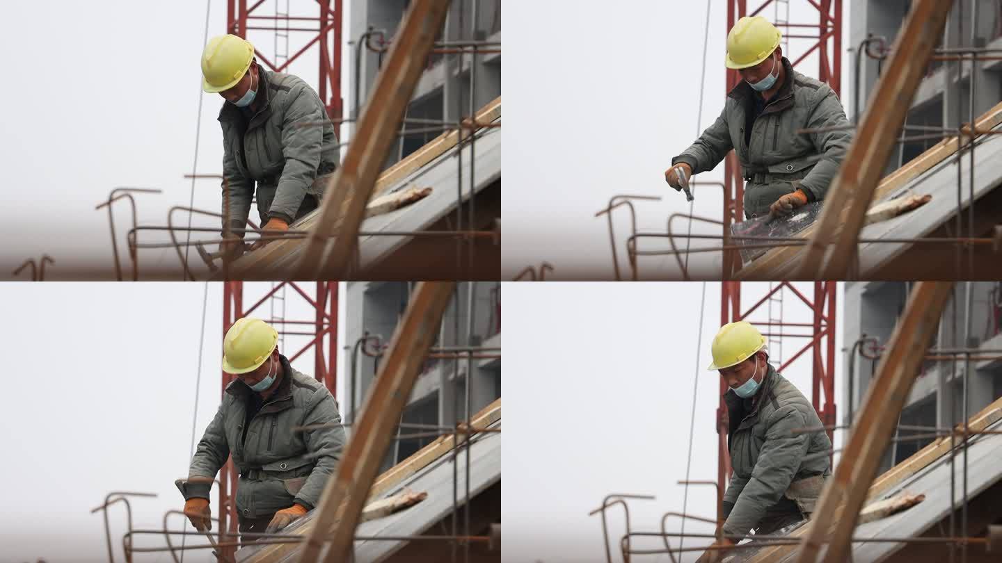 工地上民工正在钉木板维修房顶
