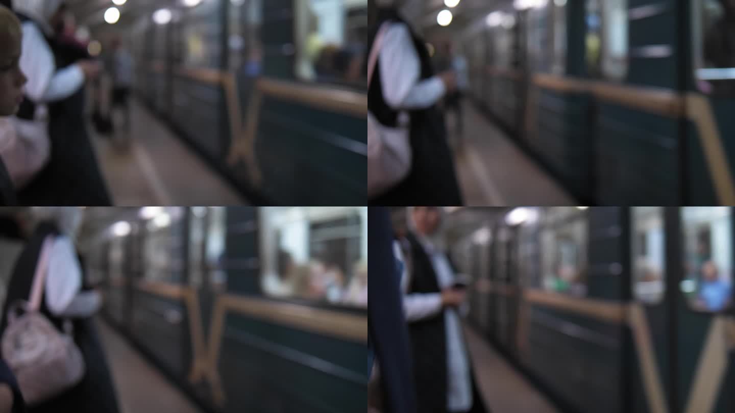 一列地铁列车驶近一个挤满了人的车站的模糊画面。
