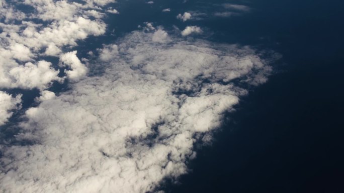 从飞机窗口鸟瞰地球。在地球上空飞行的飞机上，以电影般的慢动作俯视地球上大西洋上空的云层。