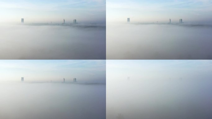 不断下降的无人机镜头潜入雾中，远处的摩天大楼隐约可见。