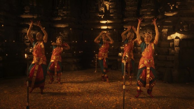 一群精力充沛的印度妇女在空荡荡的历史寺庙里欢快地跳着传统的民间舞蹈。多彩迷人的南亚文化庆典