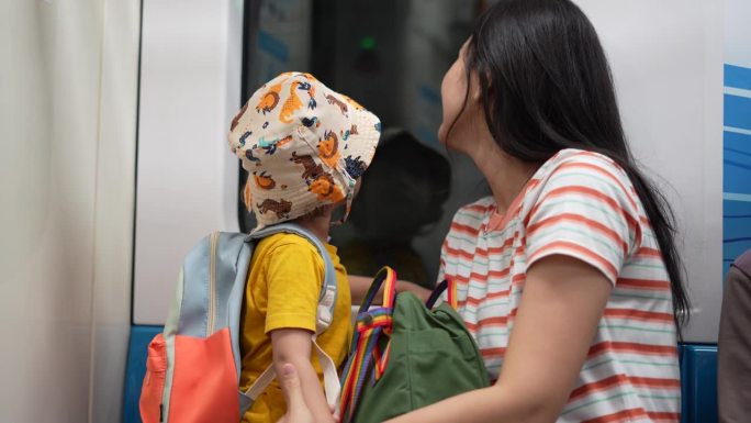 乘火车旅行时，儿子背着帆布包