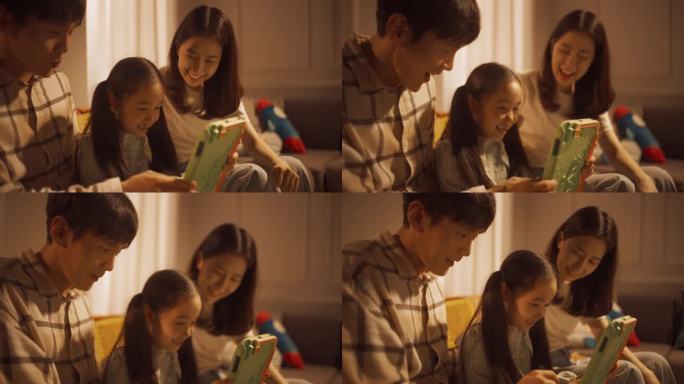 一个韩国家庭在家里用数码平板电脑共度时光的特写。年轻的父母在教育游戏中帮助他们的女儿解决问题。支持性