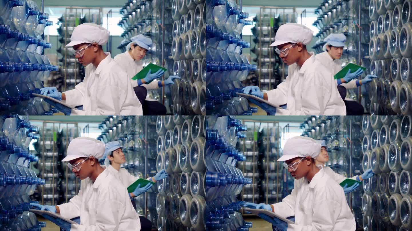 饮用水工厂工人带PPE装瓶前检查水系统。