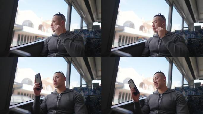 4K亚洲男子在公交车上玩手机。