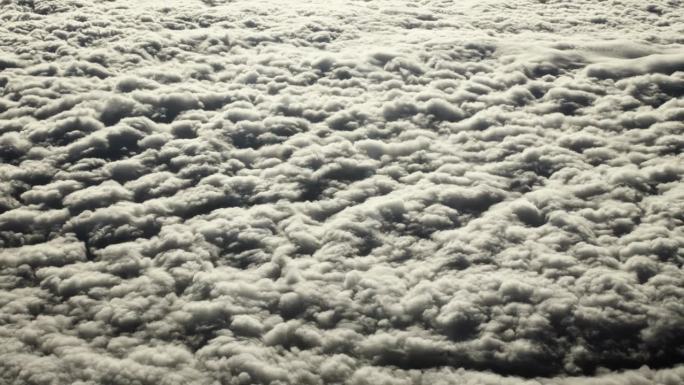 从飞机窗口鸟瞰地球。在地球上空飞行的飞机上，以电影般的慢动作俯视着大西洋上空的浮云。