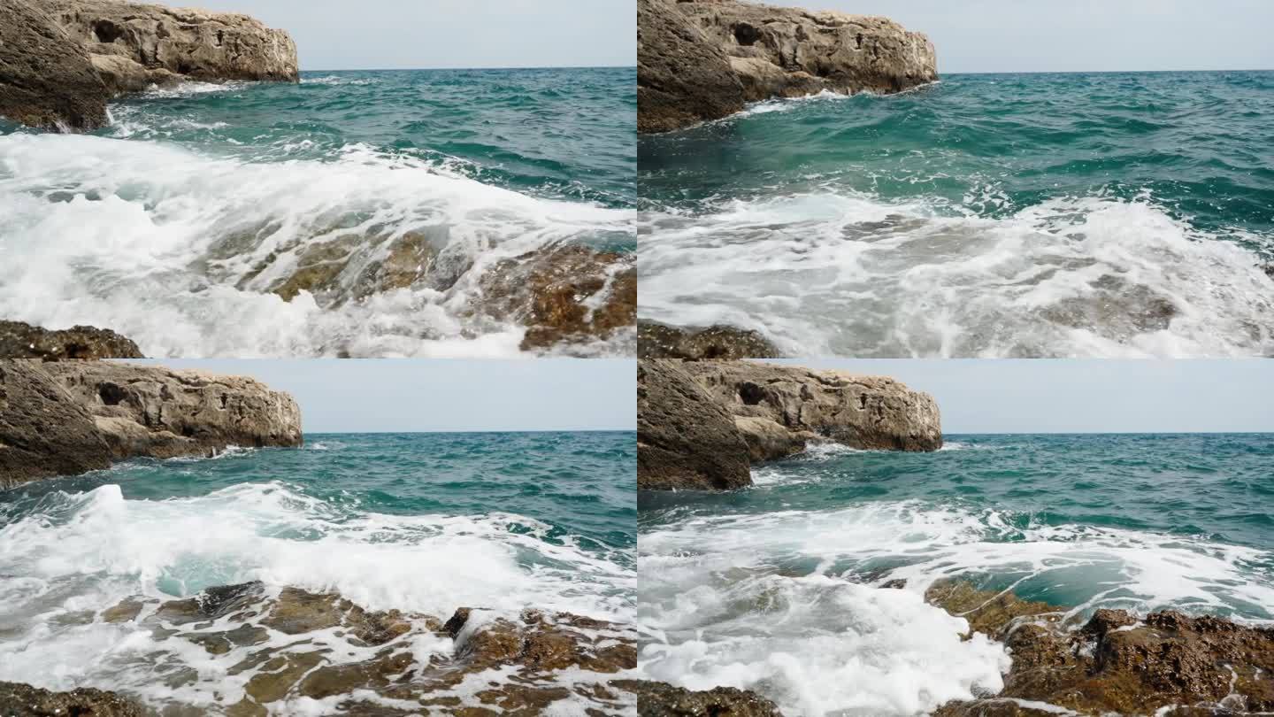 汹涌的大海和蓝绿色的海浪，泡沫撞击着海岸的岩石。