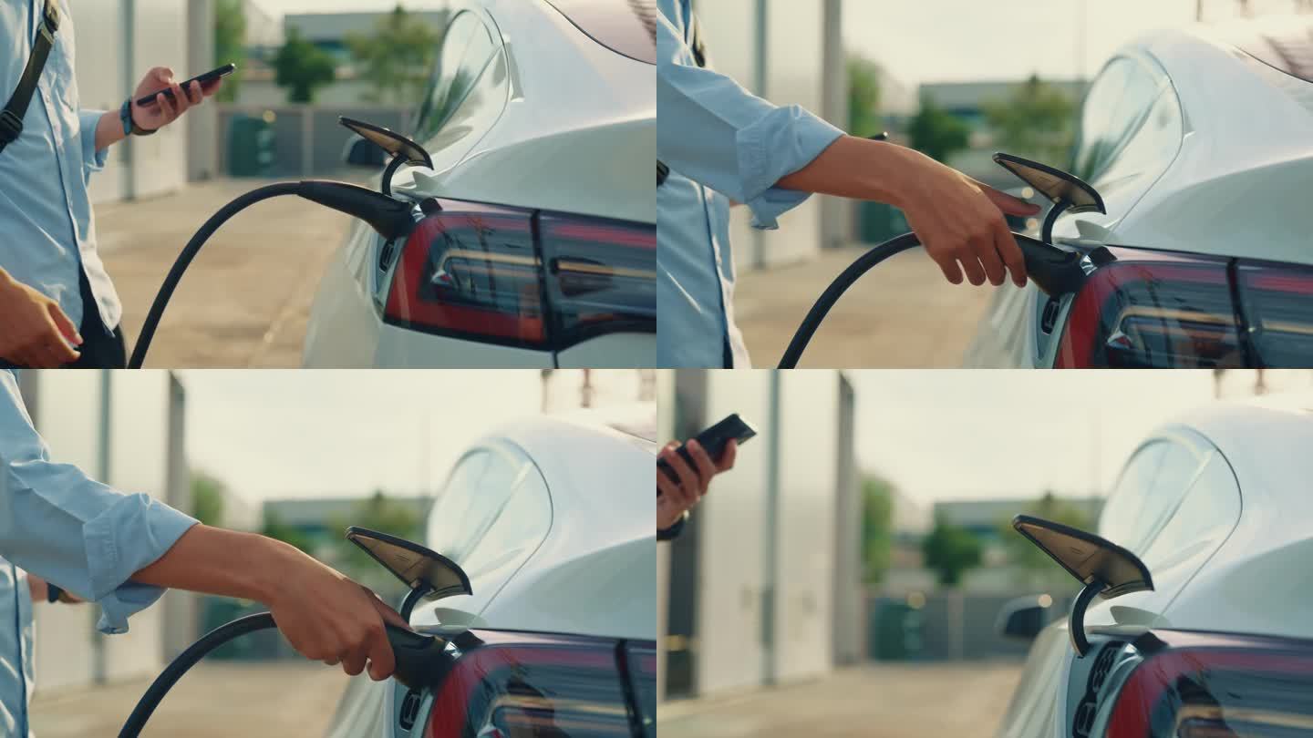 一个无法辨认的人正在用手将电动汽车插头插入汽车的进气口进行充电。