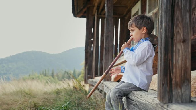 可爱的男孩演奏木管木笛-乌克兰索菲亚卡。民间音乐概念。乐器。小孩穿着传统的刺绣衬衫-维希亚万卡。孩子