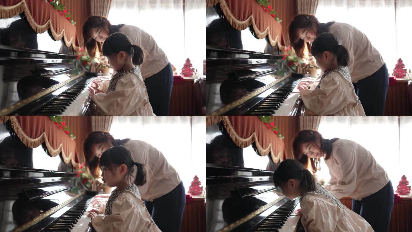 小女孩在家里和妈妈一起弹钢琴