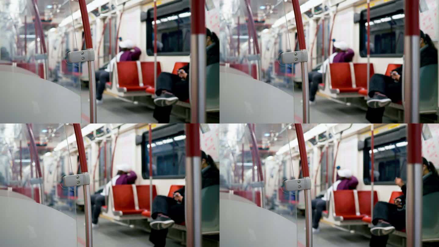 夜间乘坐地铁的乘客的散焦镜头。安静的乘客坐在靠近扶手的红色舒适车厢座椅上的动态视频。概念夜间地铁车厢