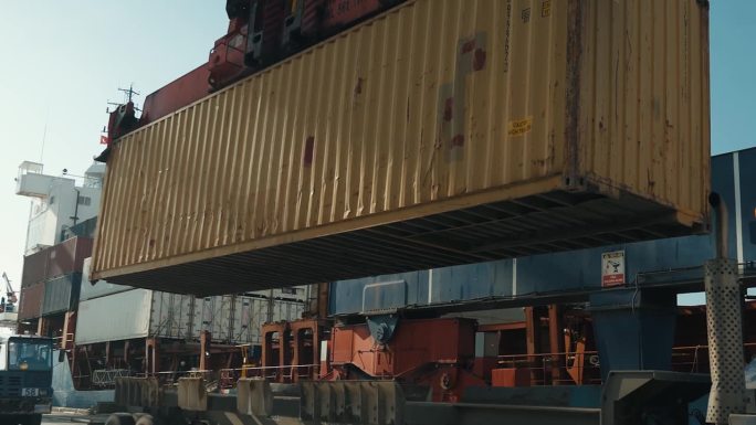 商用港口货物拖车上起重机吊起集装箱的4K实景视频。