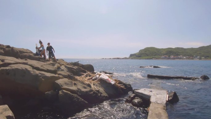 在养鱼场狭窄的混凝土人工平台上散步，与游泳者、鱼叉渔民一起眺望地平线和海岸线上的岩石形成，天气晴朗，