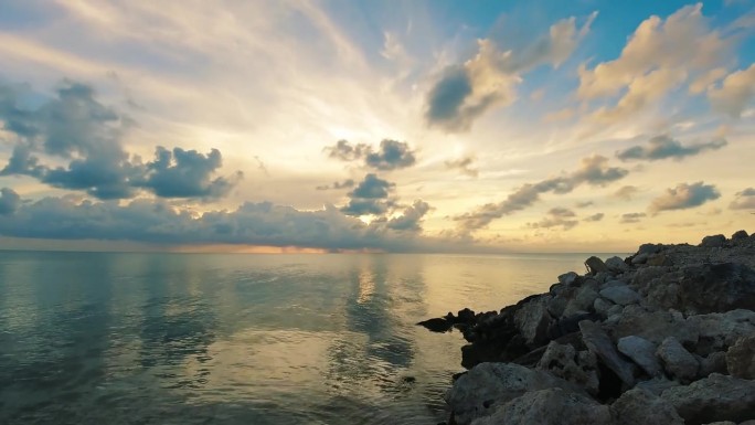 伯利兹的龙涎香礁或海湾附近的海洋上夕阳的延时拍摄。锁定广角镜头