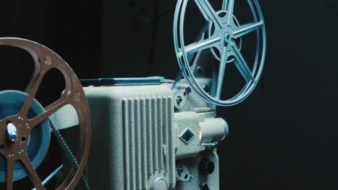 复古电影投影仪在桌子上与电影，戏剧性的照明。