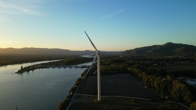 罗纳河上日出时的风力涡轮机。发电绿色能源的风电场位于法国阿尔代什小镇勒普津