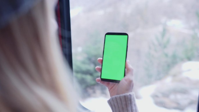 MS Woman在火车上使用绿色色度键屏的智能手机
