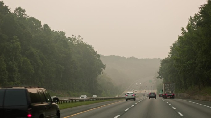 野火对道路造成的生态破坏。通往马里兰州烟雾缭绕的山区的高速公路。驾驶板摄影机运动