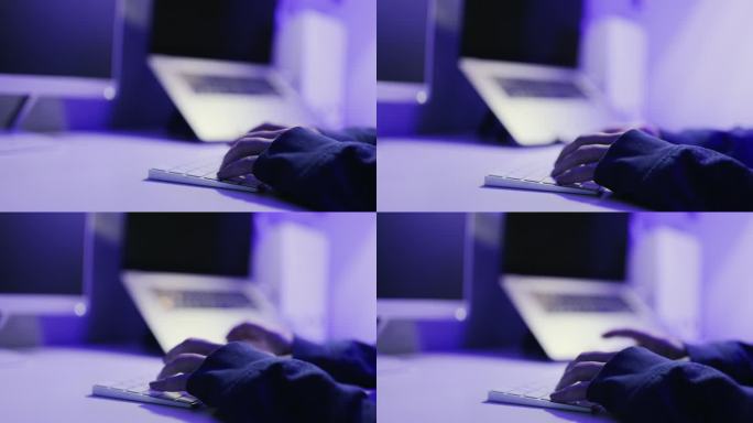 女黑客在黑暗的办公室里使用台式电脑的特写镜头