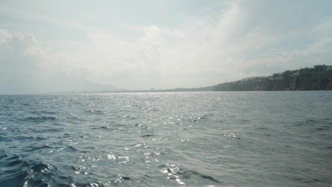 海上游览，从船上看海浪，远处悬崖上的城市，阳光明媚的天气。缓慢的运动。