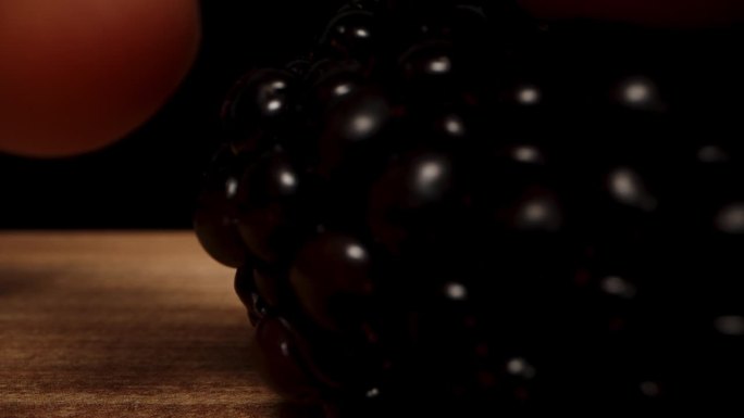 镜头靠近桌子上的黑莓，我拿了一个。多莉滑块极端特写。