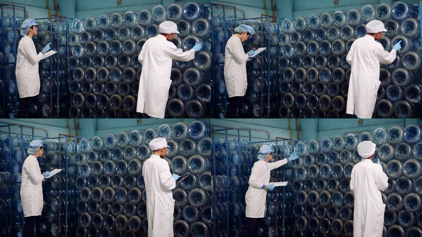 饮用水工厂工人带PPE装瓶前检查水系统。