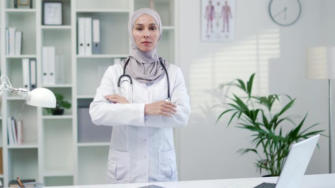 严肃自信的女医生肖像，穿着白大褂，带着听诊器，在现代医院的诊所里看着相机