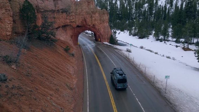 美国犹他州布莱斯峡谷国家公园内独特的拱形红色岩石形成的柏油路。无人机航拍