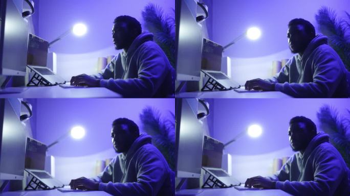 电脑黑客在紫色的霓虹灯房间里编码
