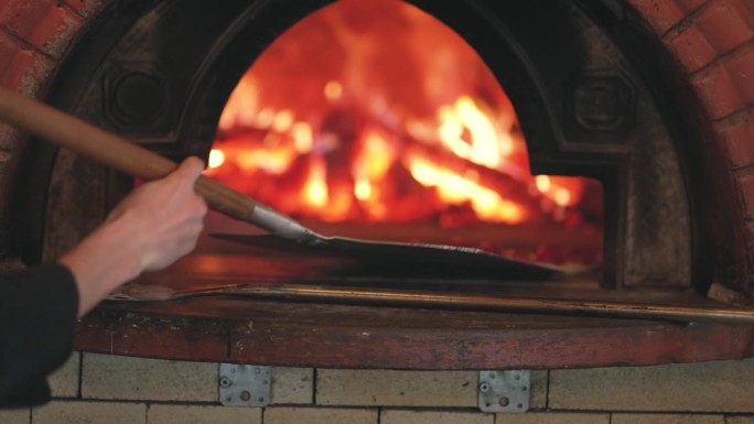 意大利披萨是用柴火烤炉做的。餐厅里的披萨烤箱。美味的披萨从烤箱里出来。