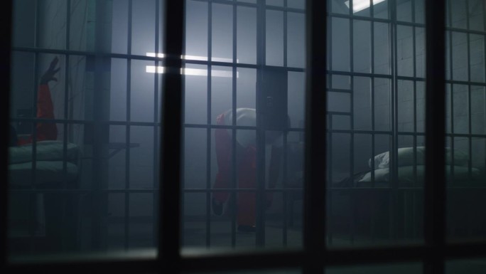 身穿橙色制服的非裔美国囚犯在牢房里拳击