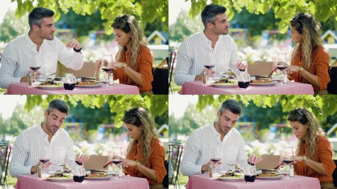 一个英俊的男人和一个美丽的女人在户外的餐桌上享受美味的食物