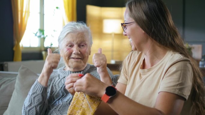 80年代，祖母为孙女织毛衣的成功而高兴，竖起大拇指，激励教织针的孙女