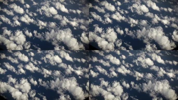 从飞机窗口鸟瞰地球。在地球上空飞行的飞机上，以电影般的慢动作俯视着大西洋上空的浮云。