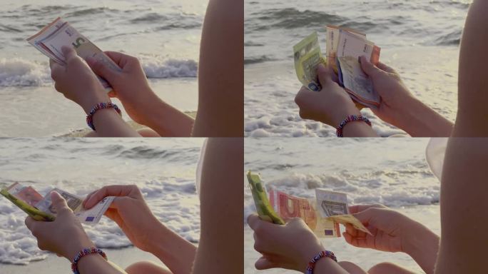 一个人拿着一把现金欣赏海景的照片