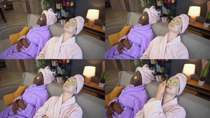 两个多种族的女性朋友带着口罩和黄瓜眼圈躺在床上放松
