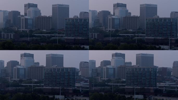 商业区的城市景观，摩天大楼在火灾烟雾中。晚上穿过弗吉尼亚州里士满的城市高速公路。航拍镜头与平移相机运