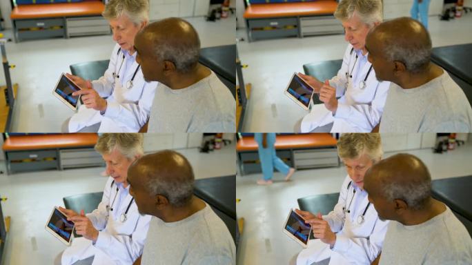 白人医生在医院一边看着黑人老人的x光片，一边向他解释受伤的原因