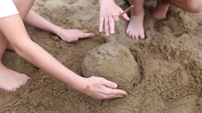 孩子们在沙滩上用手玩耍，堆沙堡