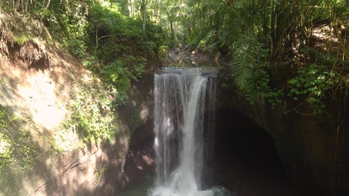 巴厘岛的苏瓦特瀑布隐藏在竹林和郁郁葱葱的绿色植被之间的热带丛林中。空中倾斜显示