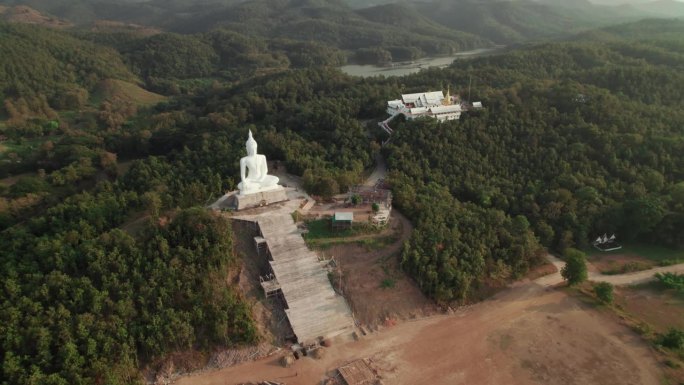 泰国乡村白色佛像和佛寺的飞景，位于森林中的寺院宁静和谐的精神度假之地