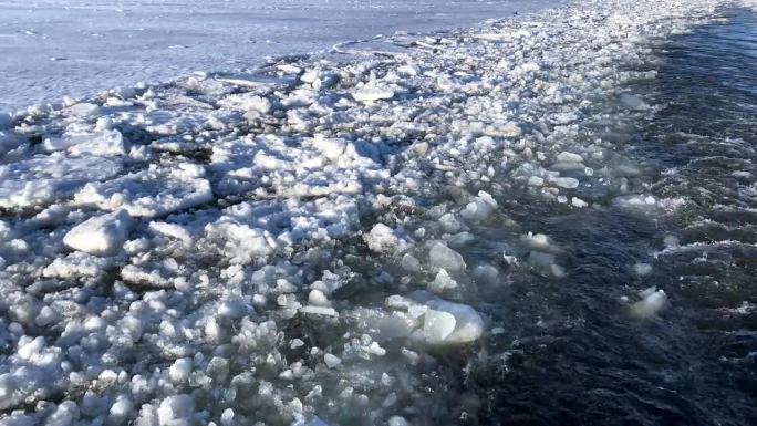 拖船沿着结冰的河流行驶后，水面上的痕迹。冰漂过程中水运的运动