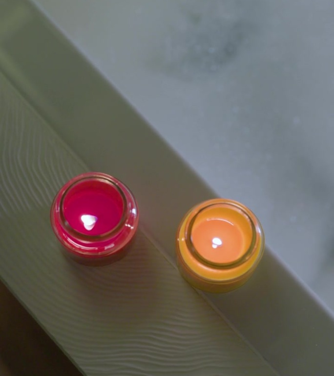 浴缸边上放着两支香薰蜡烛