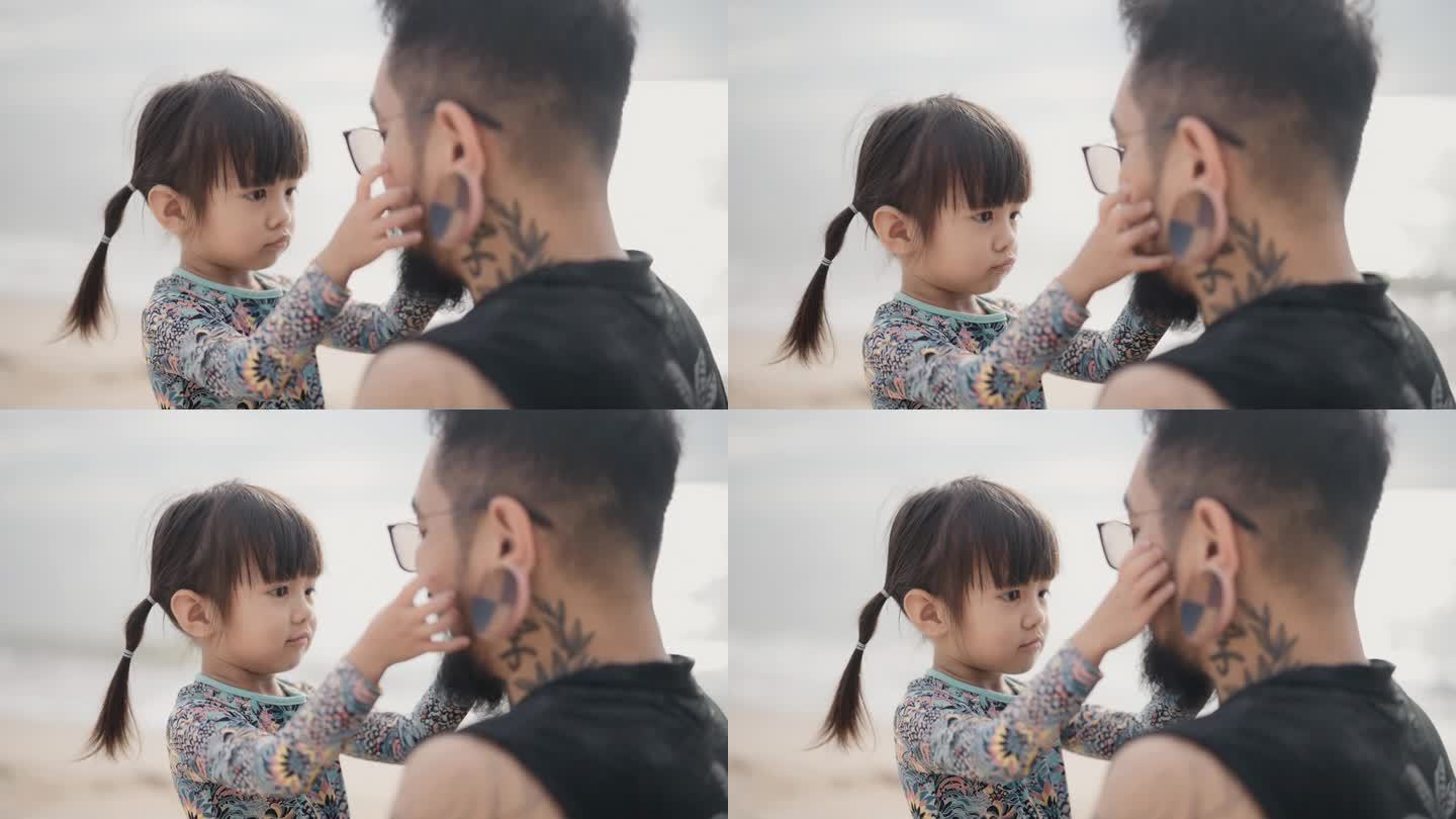 快乐的爸爸和可爱的小女儿坐在海边玩耍，一起留下珍贵的回忆。