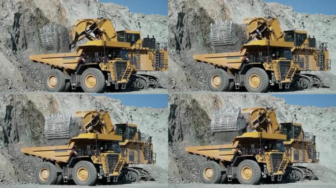在一个破碎的金矿采石场，挖掘机将碎石装进自卸卡车，慢动作