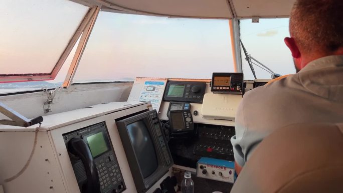 在船长的船舱里，年轻的女孩挡风玻璃驾驶方向盘黎明穿越到科弗斯岛的萨兰塔市阿尔巴尼亚司机船长成年男子在