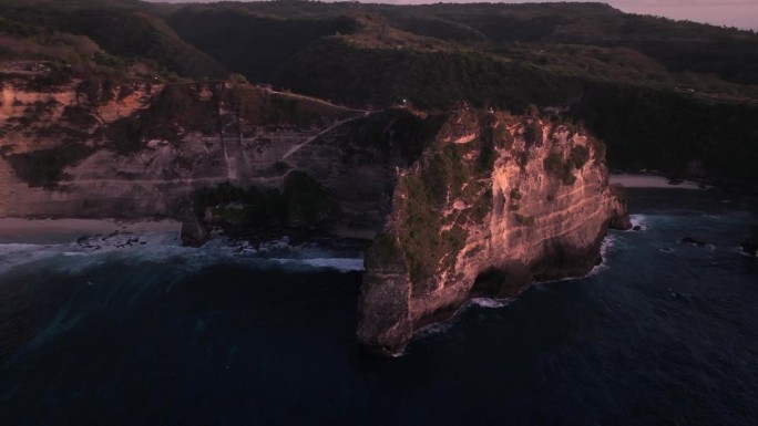 空中无人机日出场景的岩石悬崖在阿图海滩。美丽的大自然努沙Penida在巴厘岛，印度尼西亚。旅游暑假的