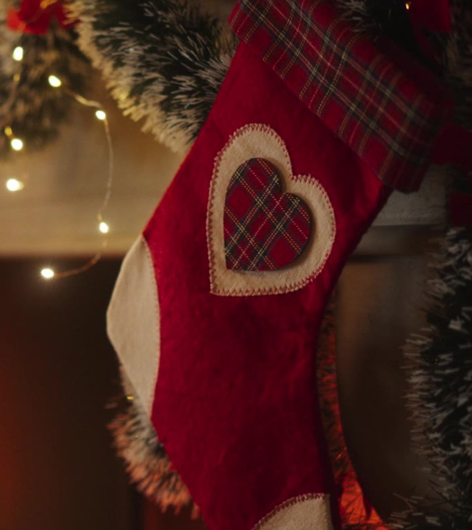 垂直屏幕:靠近装饰壁炉与长袜旁边的圣诞树。绿色和红色的花环，彩带和彩灯。平安雪夜空枪