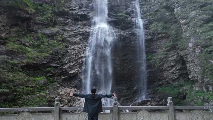 女性人物背影感受亲近自然登顶山峰瀑布水流