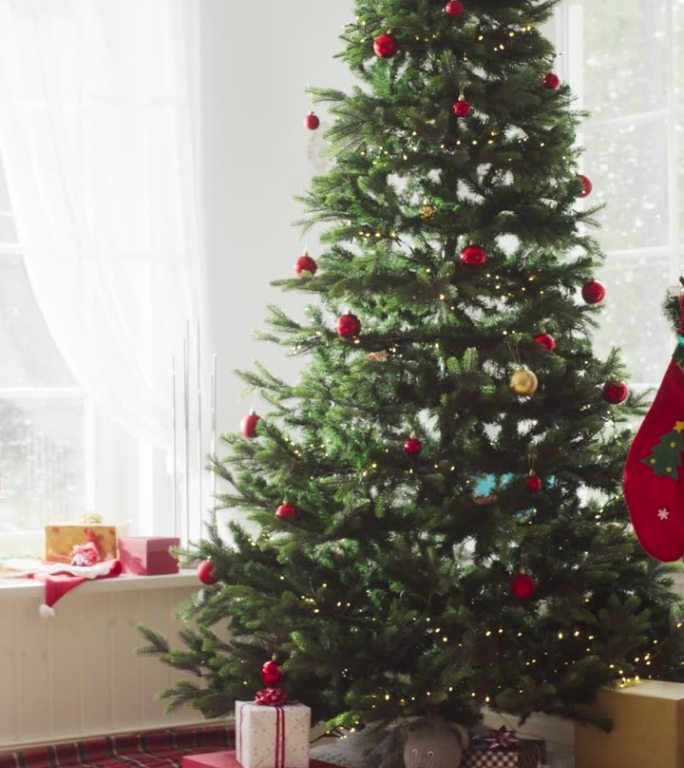 竖屏:下雪的圣诞早晨:用圣诞树和礼物装饰现代住宅的角落。一个家庭庆祝节日的家。慢动作放大，没有人